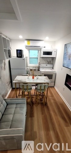 A kitchen area with a table and chairs.