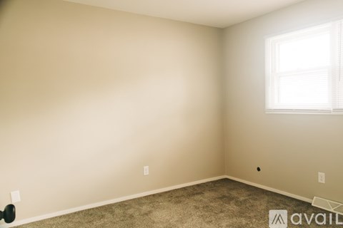 A room with a window and carpeted floor.