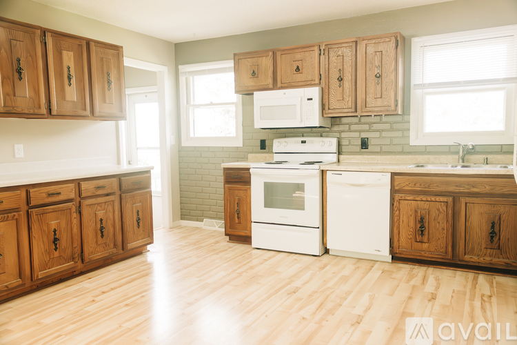 A kitchen with wooden cabinets and white appliances.