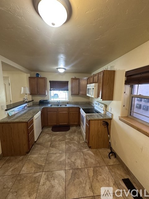 A kitchen with brown cabinets and a tiled floor.