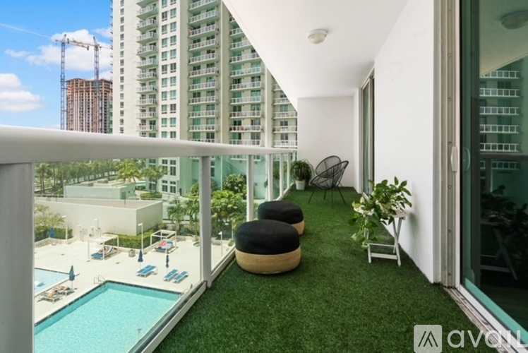 A balcony with a green lawn and a pool.