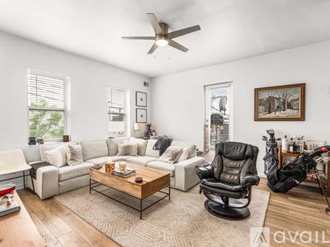 A living room with a black leather chair and a wooden coffee table.