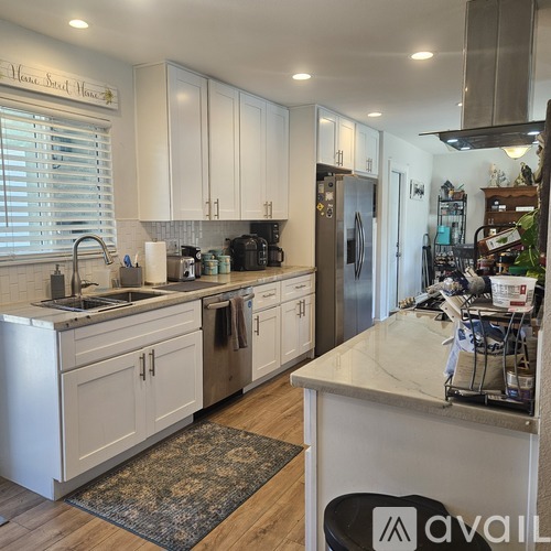 A kitchen with white cabinets and a marble countertop.