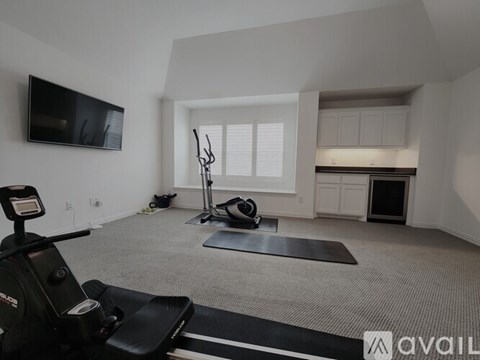 A home gym with a treadmill, exercise bike, and weights.
