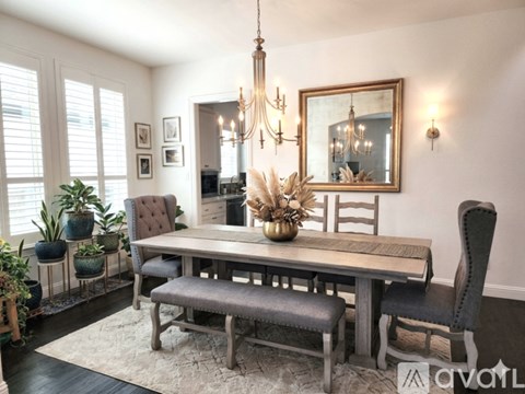 A dining room with a wooden table and chairs.