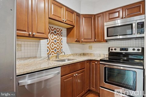 A kitchen with wooden cabinets and a stainless steel dishwasher.