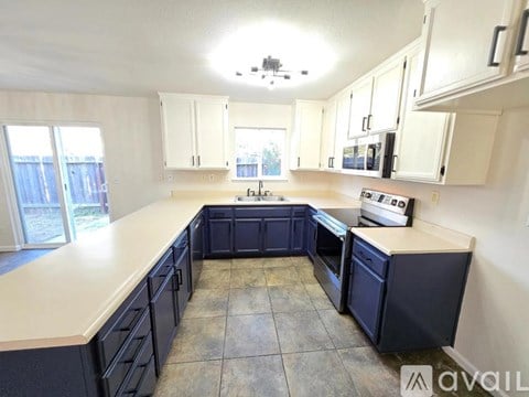 A kitchen with black cabinets and a white countertop.
