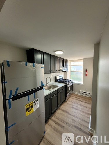 A kitchen with a refrigerator covered in blue tape.