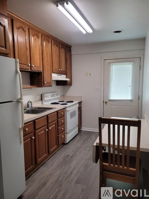 A kitchen with wooden cabinets and a white fridge.