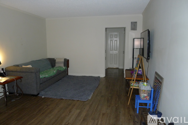 A living room with a grey couch and a wooden floor.
