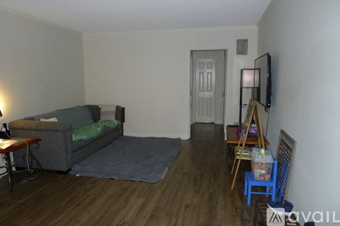 A living room with a grey couch and a wooden floor.