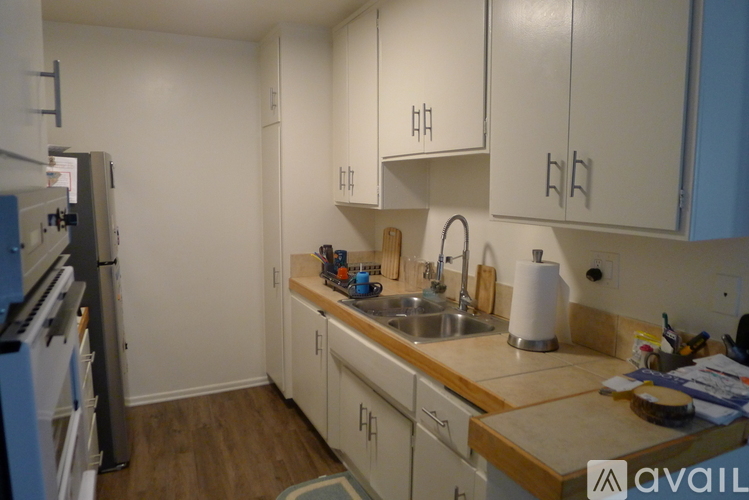 A kitchen with white cabinets and a wooden counter top.