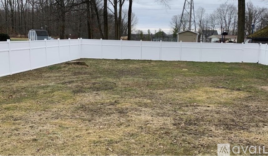 A white fence encloses a grassy yard.