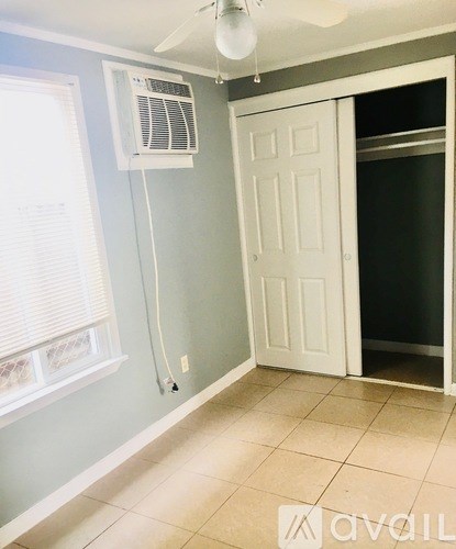A room with a white door and a window with blinds.
