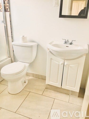 A white toilet and sink in a bathroom.