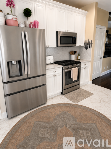 A kitchen with a stainless steel refrigerator and a black stove top oven.