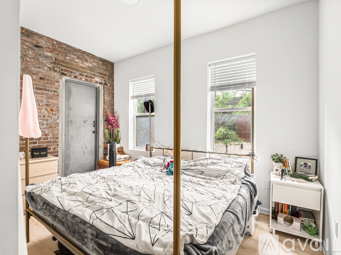 A bedroom with a brick wall and a large bed.