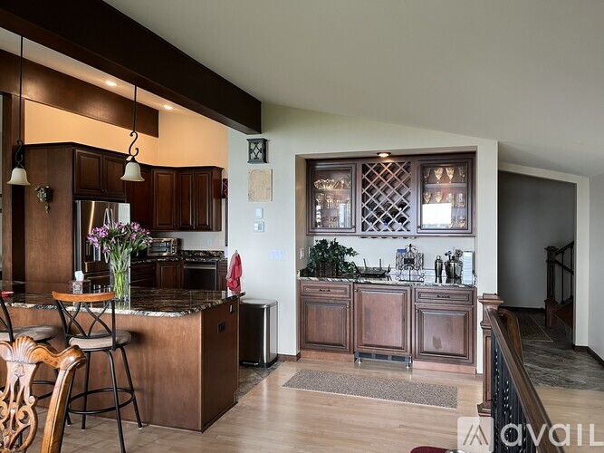 A kitchen with wooden cabinets and a bar area.