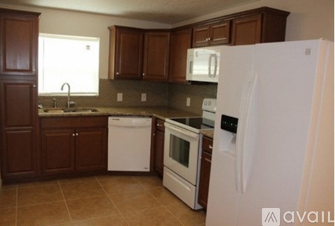 A kitchen with brown cabinets and white appliances.