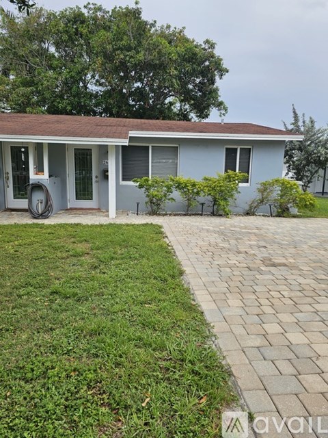 A house with a blue exterior and a brick pathway leading to the front door.