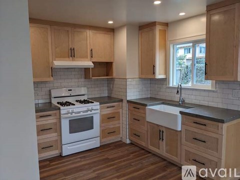 A kitchen with wooden cabinets and a white stove top oven.