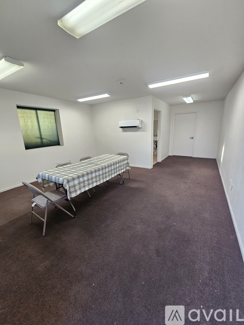 A bedroom with a bed, chair, and carpet.