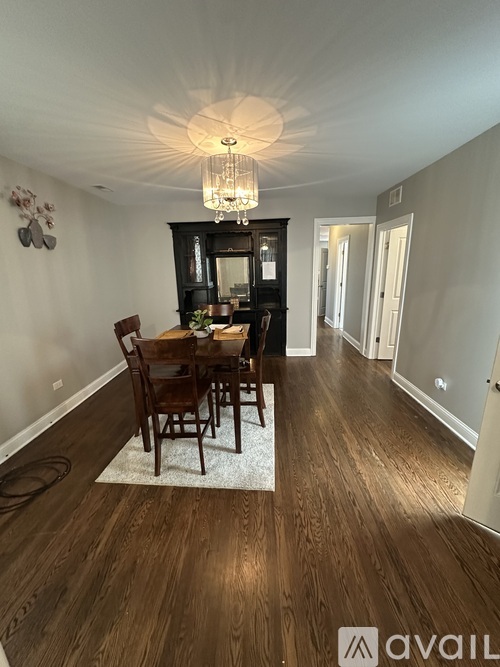 A dining room with a wooden table and chairs.