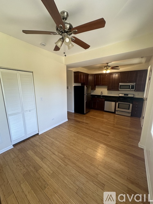 A room with wooden floors and a ceiling fan.