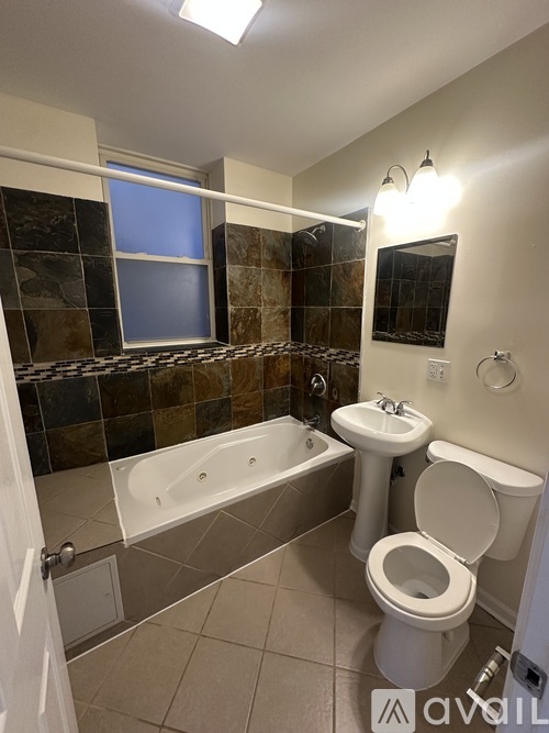 A bathroom with a toilet, sink, and bathtub.