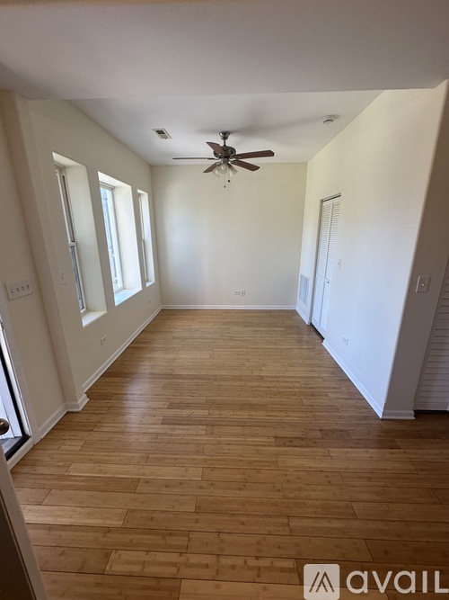 A room with wooden flooring and a ceiling fan.