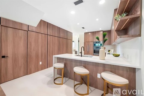 A modern kitchen with wooden cabinets and white countertops.