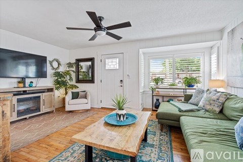 A living room with a green couch and a wooden coffee table.