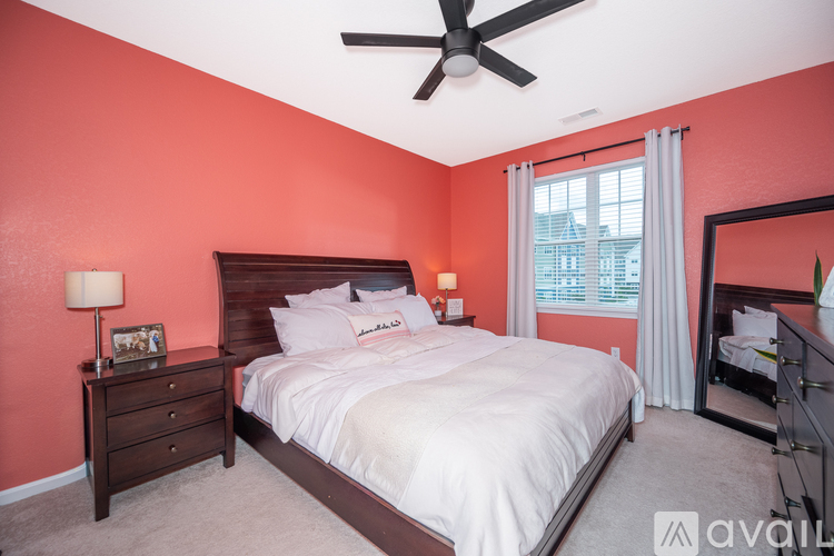 A bedroom with a bed, dresser, and ceiling fan.