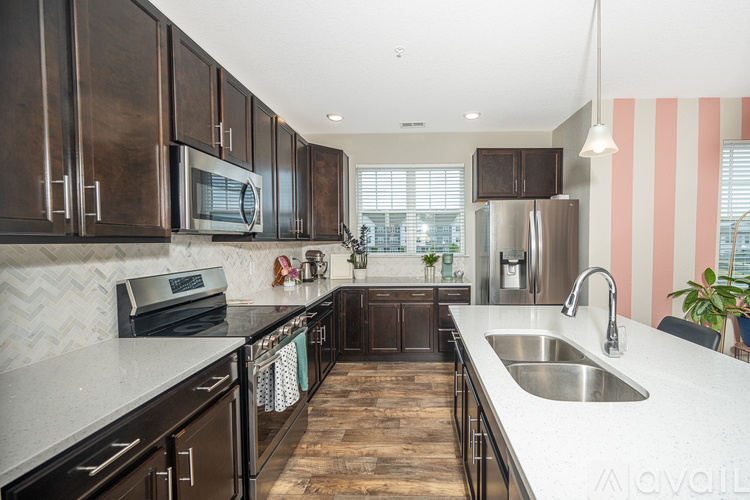 A kitchen with dark wood cabinets and stainless steel appliances.