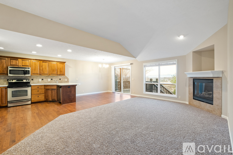 A spacious living room with a fireplace and a view of the backyard.
