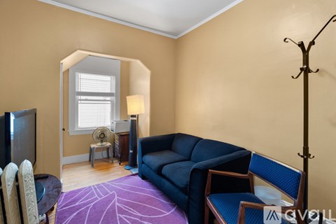 A living room with a blue couch and a television.