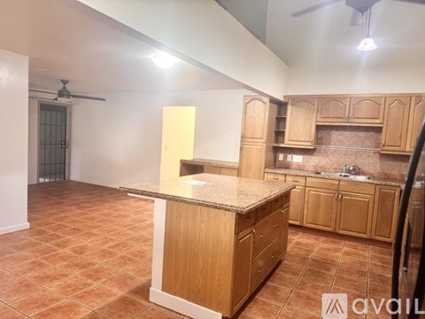A kitchen with wooden cabinets and a tiled floor.