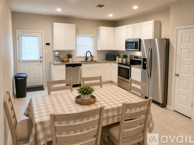 A kitchen with a table and chairs in front of it.