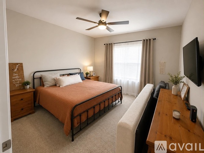 A bedroom with a bed, dresser, and television.