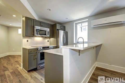A kitchen with a white counter top and a microwave above it.