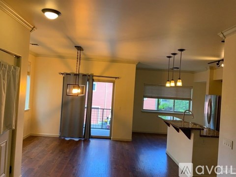 A kitchen area with a refrigerator, sink, and a window with blinds.