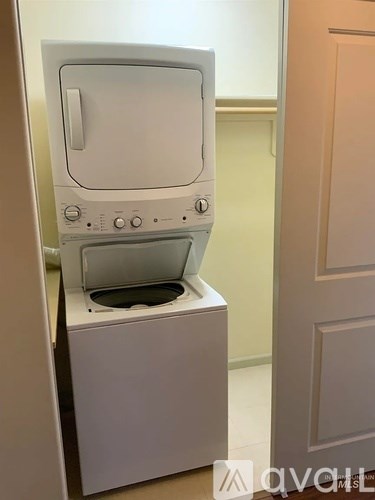 A white oven with a door open is in a room.