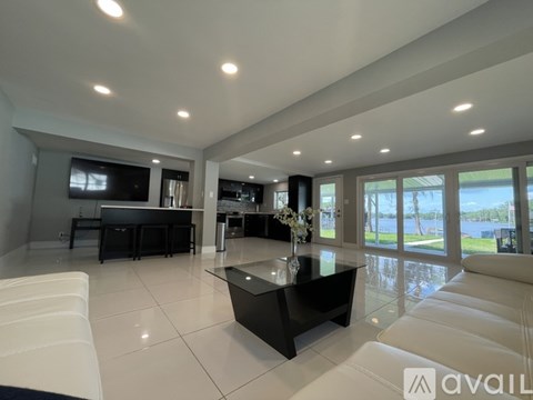 A modern living room with a black coffee table and white furniture.
