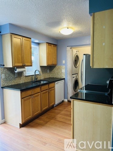 A kitchen with wooden cabinets and a black countertop.