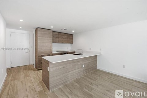 A kitchen with a white counter top and wooden cabinets.