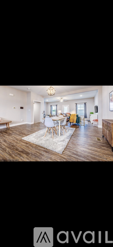A modern living room with a dining area in the background.