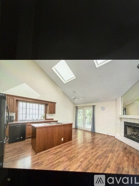 A kitchen with wooden cabinets and a black fridge.
