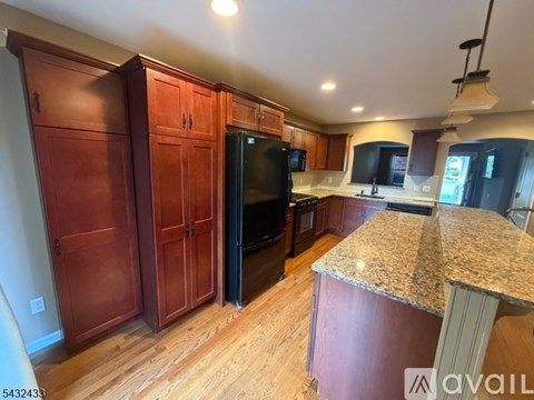 A kitchen with wooden cabinets and a granite countertop.
