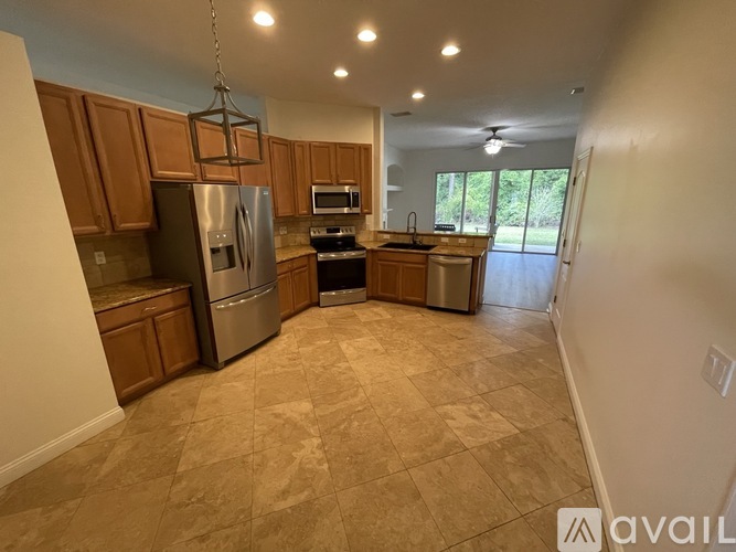 A kitchen with wooden cabinets and a tiled floor.