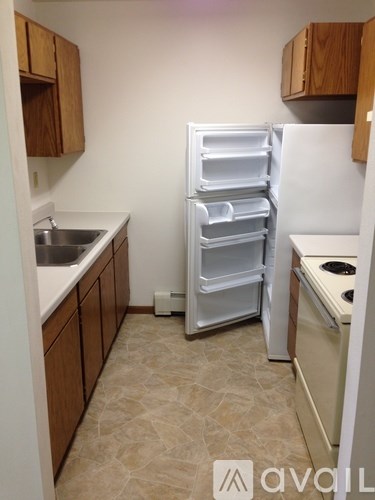 A kitchen with a white refrigerator, sink, and stove.